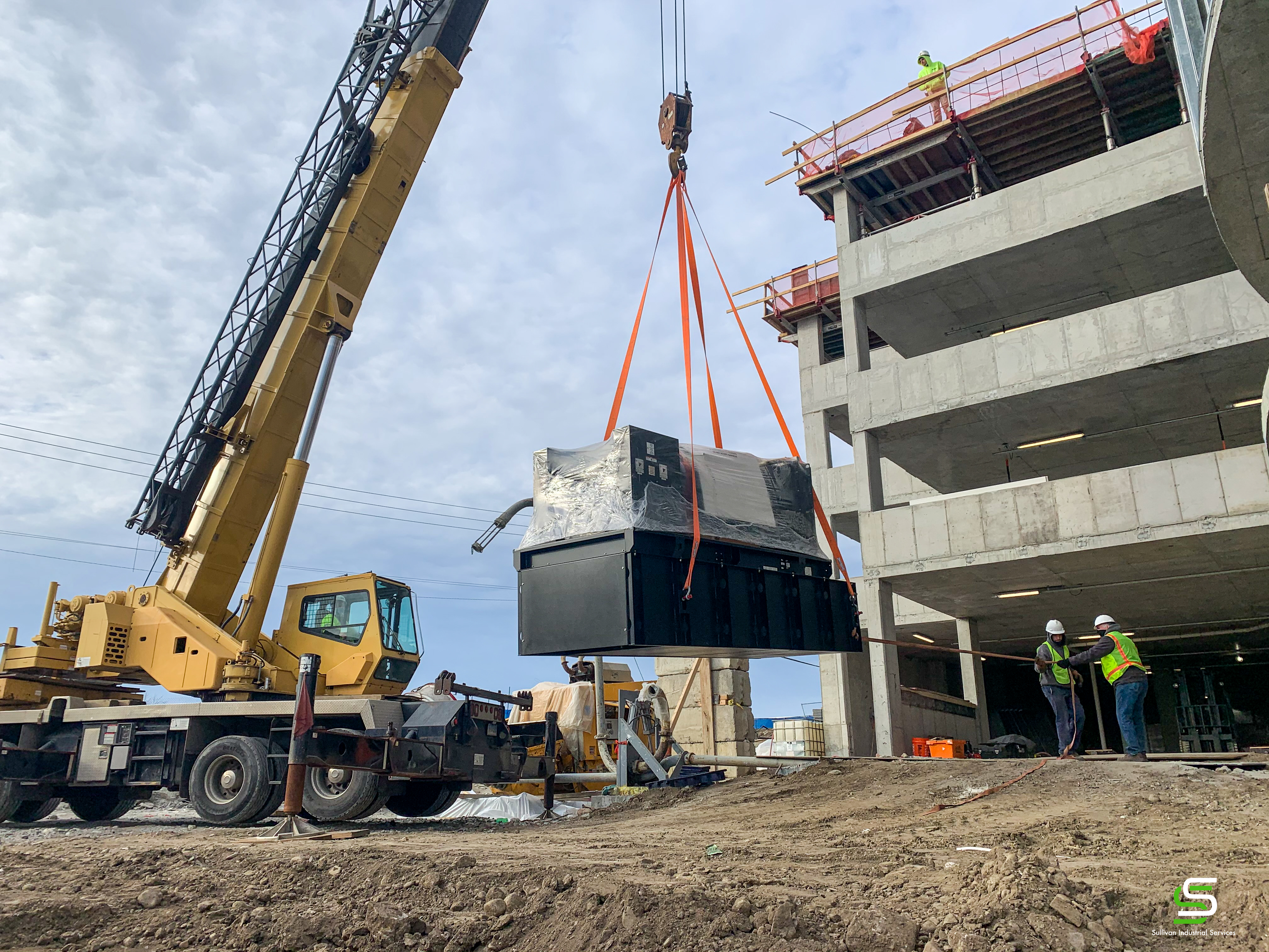 A generac generator being hoisted by a crane into place